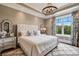Bright main bedroom features a large window, decorative curtains, and chandelier at 109 Oak Forest Dr, Kings Mountain, NC 28086