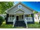 Charming home featuring a welcoming front porch, gray siding, and contrasting black accents on the brick foundation at 112 Hampton St, Chester, SC 29706