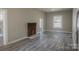 An inviting living room featuring a decorative brick fireplace, modern floors, and plenty of natural light at 112 Hampton St, Chester, SC 29706
