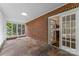 Enclosed sunroom featuring brick accent wall and tile flooring, providing a cozy and bright space at 121 33Rd Ne Ave, Hickory, NC 28601
