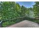 Wooden deck with black metal railing with views of lush trees and the home at 126 Meadow Glen Dr, Troutman, NC 28166