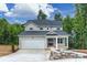 Inviting gray two-story house showcasing a covered porch, landscaping and two-car garage at 126 Meadow Glen Dr, Troutman, NC 28166