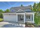 Beautiful gray home with two car garage, inviting front porch, and landscaped garden bed at 126 Meadow Glen Dr, Troutman, NC 28166