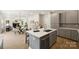 Open-concept kitchen with gray cabinets, a central island, and a seamless transition to the dining and living spaces at 126 Meadow Glen Dr, Troutman, NC 28166