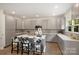 Bright kitchen featuring an island with unique black and white chairs, gray cabinets, and stainless steel appliances at 126 Meadow Glen Dr, Troutman, NC 28166
