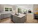 Modern kitchen island with gray cabinets, white countertops, and open view to the dining and living area at 126 Meadow Glen Dr, Troutman, NC 28166