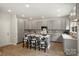 Spacious kitchen featuring an island with bar stools, gray cabinets, and stainless steel appliances at 126 Meadow Glen Dr, Troutman, NC 28166