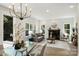 Cozy living room with a fireplace, gray sofa, modern lighting, and an open view to the dining area at 126 Meadow Glen Dr, Troutman, NC 28166