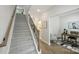 Carpeted staircase featuring a wooden handrail and decorative iron spindles, leading upstairs at 126 Meadow Glen Dr, Troutman, NC 28166