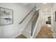 Elegant staircase with carpeted steps, wooden handrail, and wrought iron spindles at 126 Meadow Glen Dr, Troutman, NC 28166