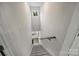 Bright stairwell featuring carpeted steps, a handrail, and a window providing natural light to the entryway at 126 Meadow Glen Dr, Troutman, NC 28166
