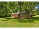 Expansive backyard showcasing brick house, wooden deck, and mature trees offering ample shade at 141 Dunlap Loop, Statesville, NC 28625