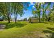 Well-manicured lawn and shed set against mature trees and blue skies, a backyard oasis for relaxation at 141 Dunlap Loop, Statesville, NC 28625