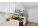 Well-lit kitchen featuring white cabinetry, modern appliances, and elegant countertops, designed for both style and functionality at 141 Dunlap Loop, Statesville, NC 28625