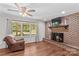 Inviting living room featuring a brick fireplace, wood floors, and a large window at 141 Dunlap Loop, Statesville, NC 28625