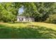 The backyard features a lush lawn and mature trees, creating a serene and private outdoor oasis at 142 Idlebrook Rd, Statesville, NC 28677