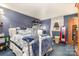 The bedroom features a bed with floral bedding, blue carpet, and a window with white curtains at 142 Idlebrook Rd, Statesville, NC 28677