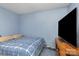 The bedroom features a bed with blue bedding, a TV, and a simple nightstand at 142 Idlebrook Rd, Statesville, NC 28677