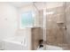 Bathroom featuring a soaking tub next to a window and a tiled standing shower with glass door at 14611 Murfield Ct, Charlotte, NC 28278