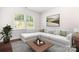 Bright living room with modern sectional sofa, wood floors, and large windows at 14611 Murfield Ct, Charlotte, NC 28278