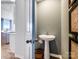 Powder room with pedestal sink, decorative mirror, and adjacent access to other rooms at 1511 River Cane St, Edgemoor, SC 29712