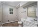 Bathroom with brown flooring featuring a toilet, sink, and small window at 1520 28Th Sw St, Hickory, NC 28602