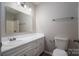 Well-lit bathroom featuring a white vanity, a large mirror, and a toilet at 1520 28Th Sw St, Hickory, NC 28602