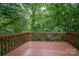 View of the backyard from the wooden deck surrounded by lush trees at 1520 28Th Sw St, Hickory, NC 28602