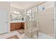 Modern bathroom with a glass-enclosed shower, a tiled floor, and wooden vanity with double sinks at 163 Carmen Way, Lancaster, SC 29720