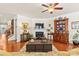 Cozy living room with a fireplace, hardwood floors, ceiling fan, and decorative furnishings at 163 Carmen Way, Lancaster, SC 29720