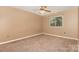 Bedroom with tan carpet, ceiling fan, and window overlooking trees at 1638 Hunters Trl, Rock Hill, SC 29732