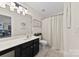 Bright bathroom featuring a vanity with ample counter space, framed art, and neutral shower curtain at 1644 Backcreek Ln, Gastonia, NC 28054