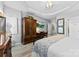 Bedroom with tray ceilings, light wood floors, a large armoire, and desk at 1644 Backcreek Ln, Gastonia, NC 28054