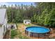 Large backyard featuring an above-ground pool, detached lounge area, and well-maintained lawn, surrounded by trees at 213 Genesis Pl, Cleveland, NC 27013