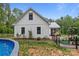 Side view of a white home with a pool, manicured lawn, and black fencing, blending rural and modern appeal at 213 Genesis Pl, Cleveland, NC 27013