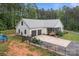 Beautiful white home features a metal roof, attached two-car garage, screened porch, and a well-manicured lawn at 213 Genesis Pl, Cleveland, NC 27013