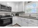 Well-lit kitchen featuring modern appliances, granite countertops, and ample storage space in white cabinetry at 2411 28Th Ne St, Hickory, NC 28601