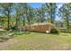 Expansive backyard featuring lush lawn, mature trees, and a brick house with a patio area, perfect for outdoor living at 2522 Doster Rd, Monroe, NC 28112