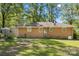 View of home's brick exterior with grass backyard and mature trees at 2522 Doster Rd, Monroe, NC 28112
