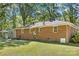 Brick home featuring a well-maintained backyard with a manicured lawn and mature trees, providing a serene outdoor space at 2522 Doster Rd, Monroe, NC 28112