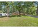 Lovely brick home nestled among mature trees, featuring a well-kept lawn and an inviting carport at 2522 Doster Rd, Monroe, NC 28112