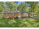 Charming single-story brick home featuring a well-manicured front yard and covered carport at 2522 Doster Rd, Monroe, NC 28112