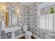 Charming powder room with custom wallpaper, pedestal sink, and natural lighting at 2814 Glendale Rd, Charlotte, NC 28209