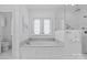 Luxurious bathroom featuring a soaking tub with marble surround and frameless shower at 2814 Glendale Rd, Charlotte, NC 28209