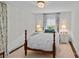 Cozy bedroom features a wood bedframe, plush rug, and floral curtains around the bright window at 2814 Glendale Rd, Charlotte, NC 28209