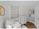 Bedroom with a white changing table, organized closet, and a comfy armchair bathed in natural light at 2814 Glendale Rd, Charlotte, NC 28209