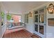 Charming front porch featuring a cozy porch swing, brick floor, and decorative lighting at 2814 Glendale Rd, Charlotte, NC 28209