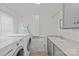 Well-equipped laundry room featuring a washer, dryer, sink, and ample storage space at 2814 Glendale Rd, Charlotte, NC 28209