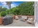 Charming brick patio with cozy seating, a grill, and lush greenery providing a private outdoor retreat at 2814 Glendale Rd, Charlotte, NC 28209