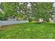 Expansive backyard featuring manicured lawn, mature trees, white fencing, and home exterior at 2844 Georgia Ave, Charlotte, NC 28205